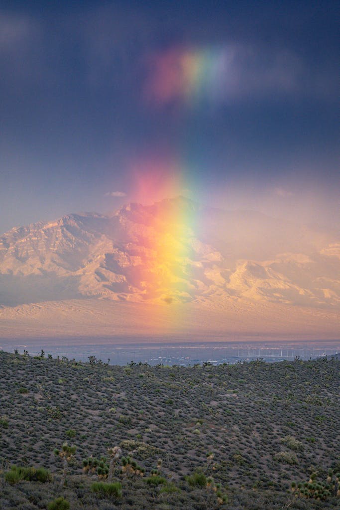 A captivating view of a rainbow illuminating Mount Charleston's snow-covered peaks, Nevada.